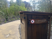 Met hout beklede <a href="/lemma/Prullenbak" class="mw-redirect" title="Prullenbak">Prullenbak</a> in het <a href="/lemma/Wandelwoud" title="Wandelwoud">Wandelwoud</a>, erop een waarschuwing dat wandelwagens echt niet mee mogen "i.v.m. brandveiligheid". Erachter <a href="/lemma/Danse_Macabre" title="Danse Macabre">Danse Macabre</a>.