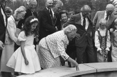 <a href="/lemma/Prinses_Juliana" title="Prinses Juliana">Prinses Juliana</a> doet haar uiterste best bij de opening van de <a href="/lemma/Wensbron" title="Wensbron">Wensbron</a>. Op de achtergrond onder andere <a href="/lemma/G%C3%A9_Rieter" title="Gé Rieter">Gé Rieter</a>, <a href="/lemma/Hans_van_Dun" title="Hans van Dun">Hans van Dun</a>, <a href="/lemma/Anton_Pieck" title="Anton Pieck">Anton Pieck</a>, <a href="/lemma/Herman_ten_Bruggencate" title="Herman ten Bruggencate">Herman ten Bruggencate</a>.