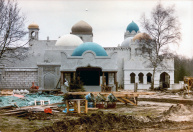 Exterieur, 04-1985. De Bazaar in aanbouw, die aanvankelijk is opgezet als balie-verkooppunt. Het is een vrij rommelig gedeelte van de bouwplaats, waar prefab onderdelen gestort worden te midden van allerlei bouwafval. Het sparretje is wellicht een overblijfsel van Kerstige aankleding van de bouwplaats.