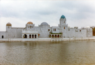 Exterieur, 04-1985. Zicht op de voorgevel, met nog maar weinig delen in de juiste kleuren afgewerkt en ingeschaduwd.