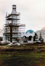 Exterieur, 04-1985. De minaret in aanbouw, inclusief de Bazaar in diens originele omvang als balie-verkoop - de helft van de huidige winkel. Het is niet duidelijk of de sparren rechts er al stonden of er in de kerstperiode geplaatst zijn.