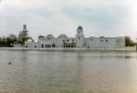 Exterieur, 04-1985. Zicht op de voorgevel, met nog maar weinig delen in de juiste kleuren afgewerkt en ingeschaduwd.