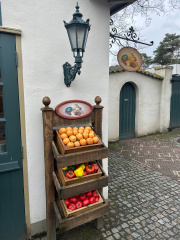 Rechter hoek van <a href="/lemma/In_de_Gelaarsde_Kat" title="In de Gelaarsde Kat">In de Gelaarsde Kat</a>, rek met fruitkistjes en fruitig uithangbordje, februari 2025