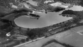 Luchtfoto van de <a href="/lemma/Kanovijver" title="Kanovijver">Kanovijver</a> en de boerderij met manege-terrein en <a href="/lemma/Consumptieverkoop_Kanovijver" title="Consumptieverkoop Kanovijver">Consumptieverkoop Kanovijver</a> midden boven, vermoedelijk jaren zestig