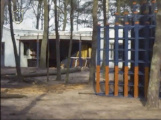 Overkapte hoek van de <a href="/lemma/EHBO-post" title="EHBO-post">EHBO-post</a> in de Speeltuin in <a href="/lemma/1977" title="1977">1977</a> met daaronder allerlei materialen opgeslagen tijdens de winterperiode. Rechts voorin de <a href="/lemma/Klimtoren" title="Klimtoren">Klimtoren</a>.