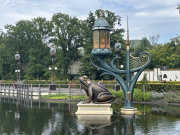 Een kikker en baken van licht van <a href="/lemma/Aquanura" title="Aquanura">Aquanura</a>, juni 2025