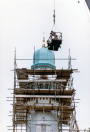 Exterieur, 06-1985. Twee mannen plaatsen een enorme bladgouden piron met halve maan op de minaret, waarmee het hoogste punt van de attractie is bereikt.