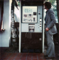 <a href="/lemma/Jan_Verhoeven" title="Jan Verhoeven">Jan Verhoeven</a> bij een <a href="/lemma/Vendingautomaat" title="Vendingautomaat">vendingautomaat</a> bij de <a href="/lemma/Smulpaap" title="Smulpaap">Smulpaap</a>, jaren zeventig