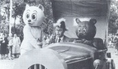 Godfried Bomans arriveert op Rommeldam in de Oude Schicht, met Tom Poes en Olivier B. Bommel aan zijn zijde. 29 juni 1955.