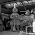 <a href="/lemma/Henk_Smulders" title="Henk Smulders">Henk Smulders</a> werkt aan de tempelwachter van de <a href="/lemma/Indische_Waterlelies" class="mw-redirect" title="Indische Waterlelies">Indische Waterlelies</a>, vermoedelijk <a href="/lemma/1965" title="1965">1965</a> in de werkplaats van de <a href="/lemma/Decoratie_%26_Vormgeving" title="Decoratie &amp; Vormgeving">vormgevers</a>