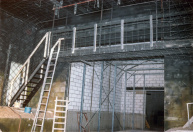 Kantelkamer en laatste Jungle, 11-1985. Een loopbrug boven de 'uitgang' van de Kantelkamer, vanuit de laatste Jungle gefotografeerd. In het zwarte raster worden later alle planten geplaatst. De loopbrug loopt tussen de opstaphal van de attractie en de (keurig betegelde) personeelsruimtes achter de scènes en is dus een veelgebruikte personeelsroute.