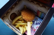 De inhoud van het <a href="/lemma/Kijkje_in_de_Keuken" title="Kijkje in de Keuken">Kijkje in de Keuken</a>: een kiplollie, frietjes, Fristi en kleurpotloodjes.