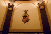 Wandornament in de <a href="/lemma/Ronde_Zaal" title="Ronde Zaal">Ronde Zaal</a> van het <a href="/lemma/Spookslot" title="Spookslot">Spookslot</a>. Een wapenschild met schedels en harten wordt gedragen door een duivelse bok. (Foto: Jos)