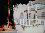 Haven, 01-1986. Het paviljoen in de haven-scène gefotografeerd vanuit een steiger in de vaargeul. Aan de linkerzijde is een eilandje met kunstgroen gecreëerd. De palmboom-stammen zijn geplaatst in pvc-pijpen die als stam zijn gedecoreerd - het kleurverschil is zichtbaar.