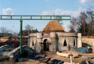 Het Lurk en Limoenhuys in aanbouw. Er wordt nog druk gewerkt aan het afwerken van het gebouw zelf. De monorailtrack ervoor eindigt abrupt in de lucht. De Laafmuur is gemetseld maar het gedeelte links moet nog aangesmeerd worden. Rechtsvoor een van de vier staalkabels die Lijn's Zweefhuys geleviteerd houden.
