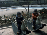 <a href="/lemma/Hobbelpaard" title="Hobbelpaard">Hobbelpaarden</a> bij de <a href="/lemma/Kleuterhof_(1960)" title="Kleuterhof (1960)">Kleuterhof (1960)</a> met op de achtergrond het <a href="/lemma/Kinderbad" title="Kinderbad">Kinderbad</a>, de <a href="/lemma/Apenmolen" title="Apenmolen">Apenmolen</a> en groepsbagagekluizen. Vermoedelijk 1980.
