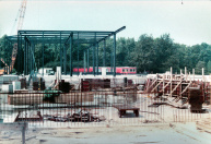 Exterieur, 09-1984. We kijken vanaf het voorplein de opstaphal in. Aan de achterzijde is men begonnen met het stalen frame waaromheen de wanden worden opgetrokken.