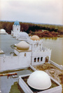 Exterieur, 04-1985. Het dak van het showgebouw, gezien vanaf de minaret. Inmiddels is de Vonderplas afgegraven tot aan de kademuren. Onder de overkapping aan de kade is men bezig met schilderwerk. Op de achtergrond goed zicht op de heuvel aan de Vonderplas met helemaal rechts de oorspronkelijke stenen brug, nog niet gestuct in de stijl van Fata Morgana zoals later het geval zou zijn.