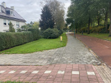 <a href="/lemma/Pastoor_Rietraweg" title="Pastoor Rietraweg">Pastoor Rietraweg</a> in oostelijke richting, richting voormalig <a href="/lemma/Rabobank" title="Rabobank">Rabobank</a>-kantoor, in oktober 20023