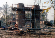 Het Lavelhuys in aanbouw: de stenen kolommen en boog zijn gemetseld, waar later de staalconstructie voor de "buik" tussen komt.