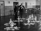 Een test met Hema-poppen voor de <a href="/lemma/Indische_Waterlelies" class="mw-redirect" title="Indische Waterlelies">Indische Waterlelies</a> in de <a href="/lemma/Panoramazaal" title="Panoramazaal">Panoramazaal</a> van het <a href="/lemma/Caf%C3%A9-Restaurant" title="Café-Restaurant">Café-Restaurant</a>. Links staat <a href="/lemma/Joop_Salet" title="Joop Salet">Joop Salet</a>.