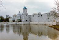 Exterieur, 04-1985. Zicht op de voorgevel, met nog maar weinig delen in de juiste kleuren afgewerkt en ingeschaduwd.