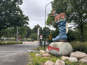 Beeld van <a href="/lemma/Klein_Duimpje" title="Klein Duimpje">Klein Duimpje</a> in Zevenmijlslaars wijst de weg naar de ingang van de parkeerplaatsen, op de Europalaan. Juni 2026 - Foto: Eftepedia