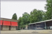 Links het <a href="/lemma/Secretariaat" title="Secretariaat">secretariaat</a> en in midden de zuilen van voormalig <a href="/lemma/Ingang_Noord" title="Ingang Noord">Ingang Noord</a> (de eerste versie) op het <a href="/lemma/Dienstencentrum" title="Dienstencentrum">Dienstencentrum</a>, recht tegenover de <a href="/lemma/Brandweer" title="Brandweer">brandweerkazerne</a> in <span class="redlink">1998</span>