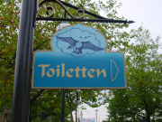 Verwijsbord (in <a href="/lemma/Vogel_Rok" title="Vogel Rok">Vogel Rok</a>-stijl) naar toiletgroep Carnaval Festival in 2001 - Foto: collectie WWCW