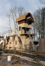 Het Lariekoekhuys in aanbouw. De gemetselde muren staan en zijn aangesmeerd, alleen de molen is nog maar rietgedekt. Het houtwerk van molen en balkon ontbreekt ook nog.