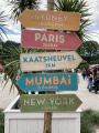 <a href="/lemma/Zomerstrand" title="Zomerstrand">Zomerstrand</a>, wegwijzers naar Sydney, Parijs, Kaatsheuvel, Mumbai en New York.