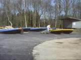Plaatsen van vers geschilderde roeiboten aan de <a href="/lemma/Roei-_en_Kanovijver" title="Roei- en Kanovijver">Roei- en Kanovijver</a>, op vers gelegd asfalt als bouwroute naar het [Spookslot]]. Rechts de <a href="/lemma/Consumptieverkoop_Kanovijver" title="Consumptieverkoop Kanovijver">Consumptieverkoop Kanovijver</a> in <a href="/lemma/1977" title="1977">1977</a>
