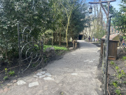 Blik op de wachtrij in het <a href="/lemma/Wandelwoud" title="Wandelwoud">Wandelwoud</a> met een sierhek, gezien in tegengestelde richting. Achteraan de uitgang van de attractie <a href="/lemma/Fabula" title="Fabula">Fabula</a>.